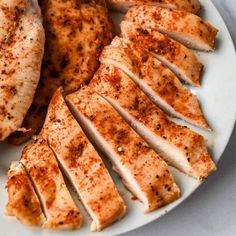 sliced chicken on a white plate with seasoning