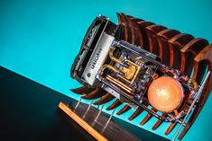 a wooden sculpture with an orange ball in it's center on top of a table