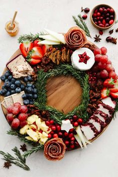 a platter filled with cheese, fruit and crackers on top of a table