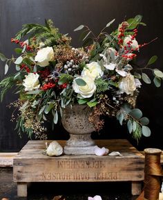 a vase filled with flowers sitting on top of a wooden box