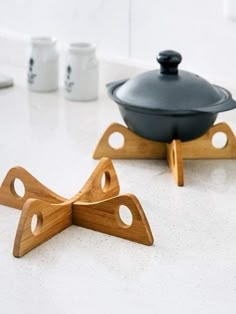 two pieces of wood sitting on top of a counter next to a pot and pan