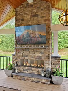 a large television mounted to the side of a brick fireplace