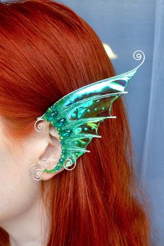 Magical mermaid ears with sparkling glass beads crafted in silver plated wire and angelina film. The film is very iridescent, so the color may vary depending on viewing angle and lightning. You mau order one or a pair of ear cuffs, for left and right ears. The ear cuffs are very easy to wear. They are designed to hook over the back of your ear like a Blue Tooth device and can be gently shaped to perfectly fit your ear. No piercing needed. They are very light in weight. Wear it to your favorite F Silver Fantasy Ear Cuff For Party, Fantasy Silver Ear Cuff For Party, Fantasy Metal Ear Cuff For Pierced Ears, Fairy Style Ear Cuff For Party, Fairy Style Ear Cuff For Party With Pierced Ears, Fantasy Metal Ear Cuff For Party, Handmade Fantasy Body Jewelry For Party, Silver Wire Wrapped Ear Cuff For Party, Party Silver Wire Wrapped Ear Cuff