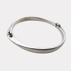 NO. (2.5) Elegant and timeless, this silver bracelet designed by Bent Gabrielsen Pedersen for Hans Hansen exemplifies the sophistication of mid-century Scandinavian design. Crafted in Denmark during the 1960s, this piece features a clean, minimalist aesthetic with two linked segments connected by silver hoops, creating a subtly expressive form that sits gracefully around the wrist. A perfect addition for collectors of mid-century modern or Scandinavian jewelry, this bracelet is both a stylish ac Formal Modern Sterling Silver Bracelet, Modern Bangle With Sterling Silver Clasp, Modern Sterling Silver Oyster Bracelet For Formal Occasions, Contemporary Sterling Silver Bracelet For Formal Occasions, Modern Engraved Bangle For Formal Occasions, Modern Engraved Sterling Silver Bangle Bracelet, Modern Oval Sterling Silver Bracelet With Polished Finish, Modernist Sterling Silver Oyster Bracelet For Formal Events, Modernist Sterling Silver Oyster Bracelet For Formal Occasions