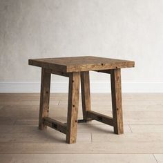 a wooden table sitting on top of a hard wood floor next to a white wall