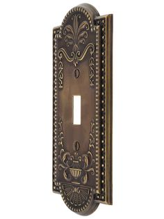 an ornate light switch plate cover in antique brass finish with decorative designs on the front and sides