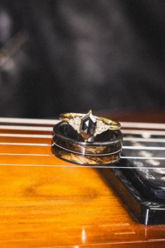 two wedding rings sitting on top of an electric guitar string, with the strings still attached