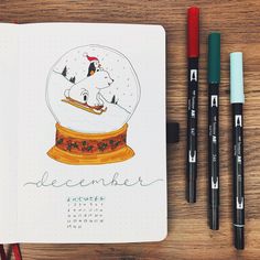 a notebook with a drawing of a dog in a snow globe on top of it