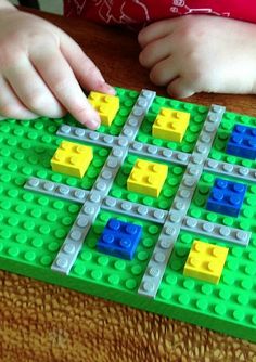 a child is playing with legos on the table