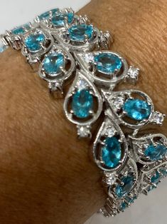 This Blue Topaz bracelet is very lively and bright. The stones are deep colors and well matched. The sterling silver is plated with rhodium to protect the bracelet from tarnish and give the appearance of white gold. 21 grams in weight. 7.5 inches or 8 inches All jewelry is shipped in a nice gift box. Check out our over a THOUSAND great reviews Engraving is $4 per letter and is not always perfect depending on the piece. It can take a few days if the jeweler is busy. This is payable to Paypal Judi Luxury Silver Bracelet With Blue Topaz, Luxury Silver Bracelets With Blue Topaz, Elegant Turquoise Sterling Silver Bracelet, Fine Jewelry Silver Bracelet With Blue Topaz, Elegant Turquoise Gemstone Sterling Silver Bracelet, Silver Blue Topaz Bracelet Fine Jewelry, Silver Blue Topaz Bracelets Fine Jewelry, Luxury Blue Gemstone Sterling Silver Bracelet, Silver Blue Topaz Bracelets For Anniversary