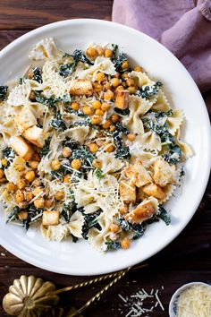 pasta with chickpeas, spinach and parmesan cheese in a white bowl