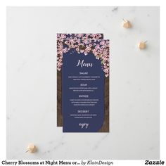 a blue menu card with pink flowers on it