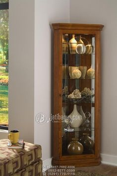 a wooden cabinet with glass doors in a living room