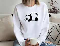 We have both bella canvas and gildan softstyle shirts in our stock. We usually ship what we have in stock at that time. Please ask for YOUTH , TODDLER and BABY Sizes  Laying Panda Sweatshirt, Lazy Panda Sweatshirt, Animal Lover Sweater, Cute Panda T-Shirt, Baby Panda Shirt, Gift for Lazy People, Panda Tee 🔆30% OFF SALE FOR OUR BEST SELLING SHIRTS 🔆 📏Note: Our shirts are Unisex style. This is in between women's and men's sizes. Comfy laid-back style. If you are wanting the shirt to be more fitted, you can order one size down. If you are wanting a roomier shirt for comfort and oversize styling, then you can order your regular size. CUSTOMER SERVICE 😍 Customer service is always our most important priority. Leaving our customers happy is what drives and motivates us. If you have any questi Casual Cotton Sweatshirt With Custom Print, Casual Long Sleeve T-shirt With Custom Print, Cute White Sweatshirt With Screen Print, Casual Long Sleeve Custom Print T-shirt, Casual White Sweatshirt With Cartoon Print, White Cartoon Print T-shirt For Loungewear, Casual Long-sleeve Custom Print T-shirt, Panda Tshirt Design Ideas, Lazy Panda