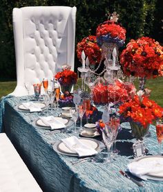 the table is set with orange flowers and silverware for an elegant dinner party or reception