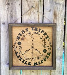 a sign hanging on the side of a wooden fence that says stay trip, little hippie