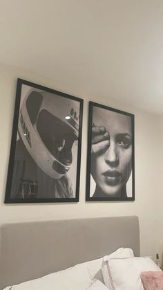 two black and white pictures hang on the wall above a bed in a bedroom with pink accents