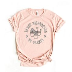 Looking for a cute versatile top to wear this summer? Make sure to grab one of our Caffeine And Kindness tees! This soft and comfortable graphic tee is the perfect top for any outfit. It can be paired with biker shorts, jeans, or even a simple skirt/dress! This tee is true-to-size, so be sure to order your regular t-shirt size! If you are looking for a more oversized look, make sure to size up! Pink Casual Tops With Comfortable Fit, Casual Pink Tops With Comfortable Fit, Spring Graphic Tee With Text Print, Spring Graphic Tee Shirt With Funny Text, Pink Graphic Tee With Plant Print, Plant Shirts Tees, Pink T-shirt With Funny Print For Everyday Wear, Pink T-shirt With Funny Print For Everyday, Everyday Pink T-shirt With Funny Print