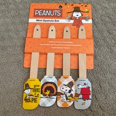 the peanuts mini spatula set has five wooden spoons with cartoon characters on them