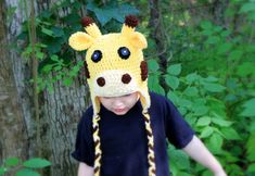 a young boy wearing a crocheted hat with a giraffe face on it