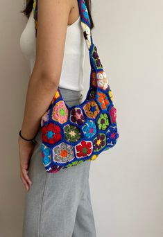 a woman is holding a crocheted purse