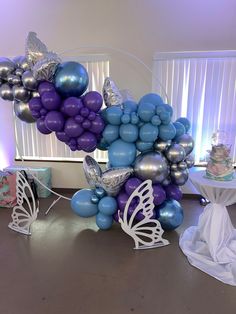 balloons and butterflies are arranged in the shape of a butterfly on top of a table