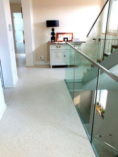 an empty room with glass railings and white carpeted flooring on the ground