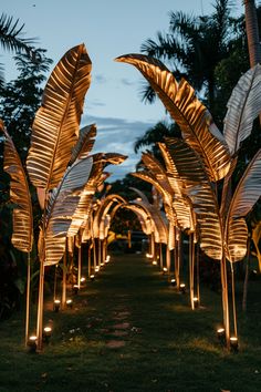 lighted palm trees are lined up in the grass