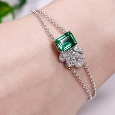 Shimmering with your affection, this bracelet shoots straight to her heart. Crafted in sterling silver, it features a glittering emerald cut stone to bring out it's beauty and sparkle. Additional stones form leaf-shaped design to add more elegance to this bracelet. She'll admire the nature-inspired details of this lovely leaf bracelet.Carat Weight: 2.76 ctStone Size: 8*10 mmNumber of Stones: 1 Stone Shape: RadiantStone Color: Emerald GreenCarat Weight: 0.65 ctStone Size: 1.2,1.1,1,0.8,1.8,1.7,1. Luxury Emerald Cut Bracelets For Anniversary, Luxury Diamond Bracelet With Gemstone Accents, Luxury Multi-stone Diamond Bracelet For Gift, Luxury Birthstone Bracelets In Fine Jewelry Style, Classic Luxury Diamond Bracelet With Emerald, Luxury Gold Bracelet With Emerald, Luxury Green Emerald Tennis Bracelet, Diamond Bracelet Design, Art Jewelry Design