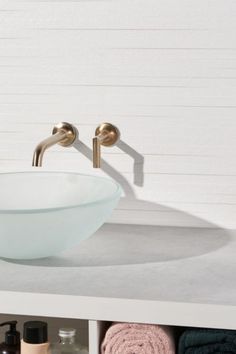 a white sink sitting on top of a counter next to towels and other bathroom items