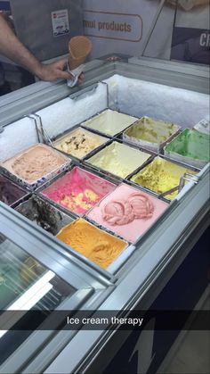 an ice cream shop display case filled with lots of different colored icecream treats