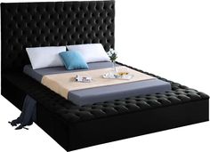 a black bed with blue and white pillows on it's headboard, in front of a white background