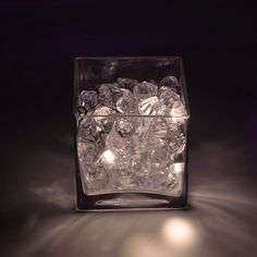 an ice cube is lit up with lights in the dark, and it appears to be filled with small pieces of ice