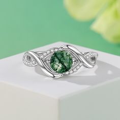 This sterling silver ring features a round green moss agate stone as the main stone that radiates a mysterious and enchanting glow. Symbolizing calm and vitality, the green moss agate's unique colors and textures seem like a painting of nature, while the infinity symbol's design symbolizes endless emotion and commitment. Whether worn as everyday jewelry or as a gift for a special occasion, this moss agate ring will add a unique charm to your appearance.Weight: 3.6 gMaterial: 925 SilverPlating Color: Silver Green Emerald Crystal Ring, Elegant Silver Moss Agate Rings, Green Crystal Gemstone Ring, Green Gemstone Crystal Ring, Green Round Crystal Promise Ring, Green Crystal Round Promise Ring, Elegant Green Moss Agate Rings, Green Sterling Silver Crystal Ring, Green Emerald Ring For May Birthstone