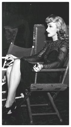 a woman sitting in a chair with her legs crossed