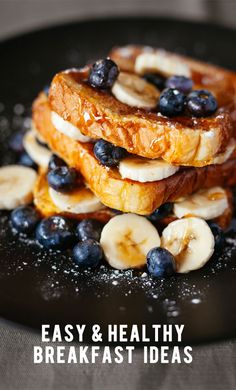 some bananas and blueberries are stacked on top of each other in a black plate