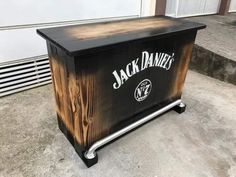 a wooden box with the name jack daniels on it sitting in front of a building