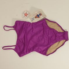 a purple swimsuit with a book on it and a button in the back that is open