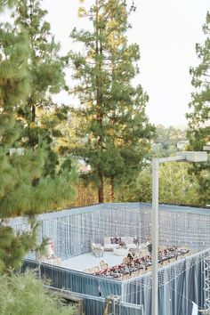 an unfinished pool surrounded by pine trees in the middle of a forest with blue tarp covering it