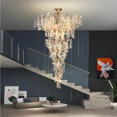 a chandelier hanging from the ceiling in a living room with stairs leading up to it