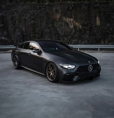 a black car parked in front of a mountain