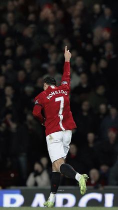 a man in red jersey kicking a soccer ball