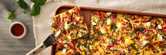 a pizza sitting on top of a pan covered in cheese and veggie toppings