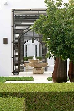 two large vases sitting in the middle of a garden