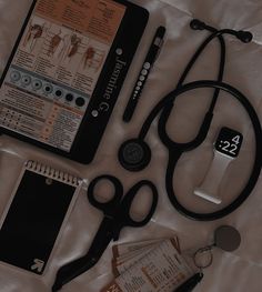 an assortment of medical supplies laid out on a white sheet, including a stethoscope and clipboard