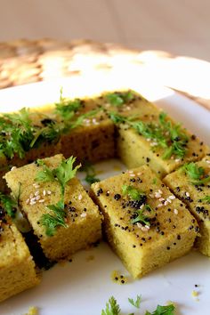 several pieces of food on a white plate with parsley sprinkled around it