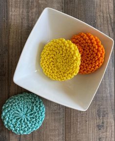 two crocheted coasters on a white plate next to each other in different colors