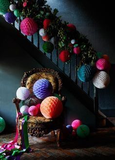 a chair sitting on the ground next to a stair case with paper balls all over it