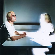 a man and woman sitting at a table in front of a light shining on them