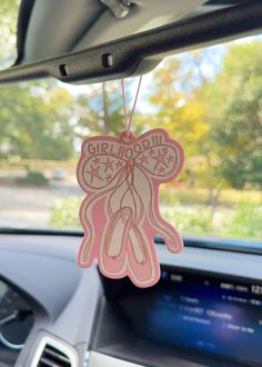 a car dashboard with a pink sticker hanging from the dash